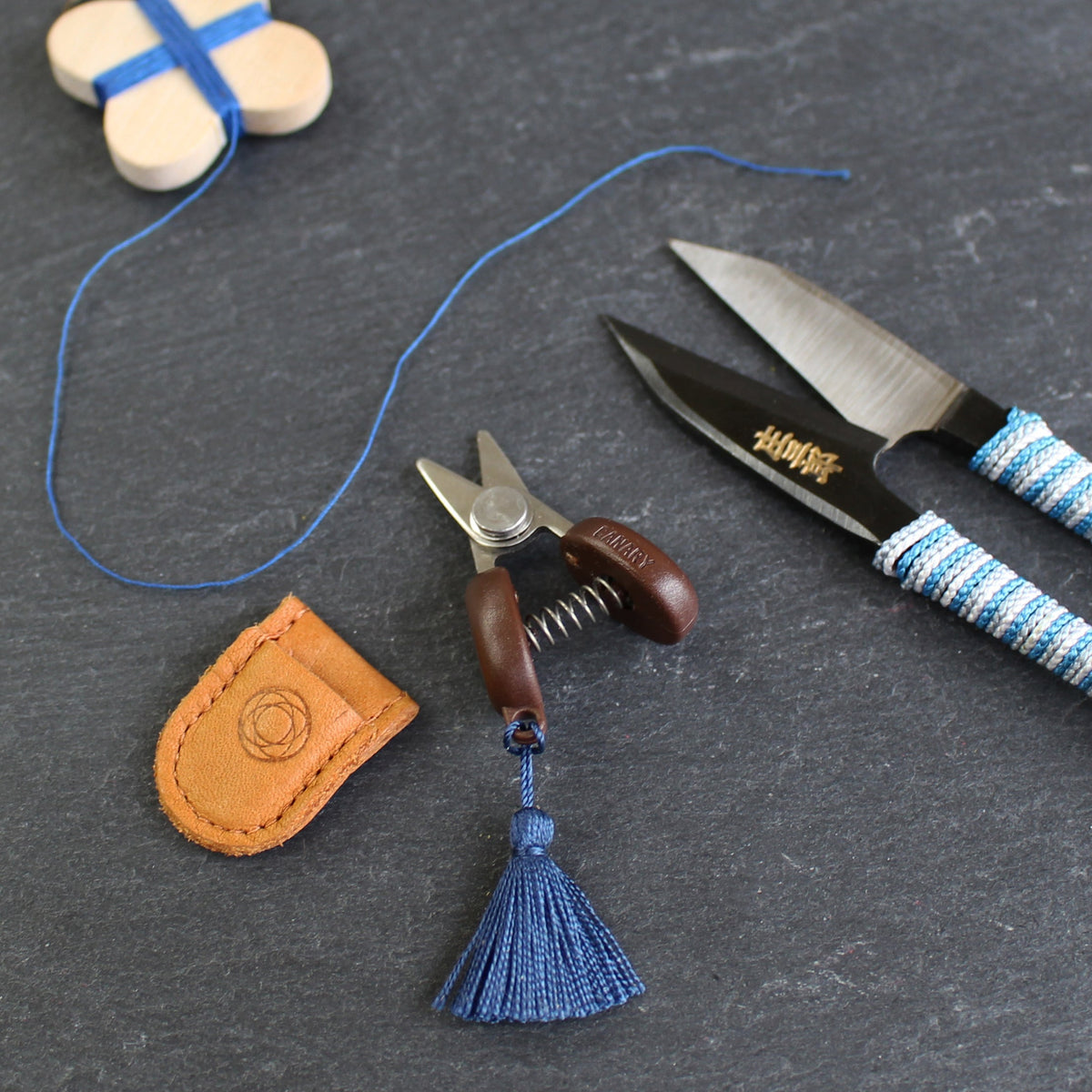 Cohana Seki mini scissors, with a leather sheath on a sewing table