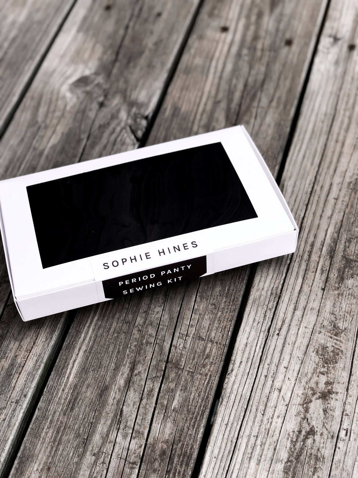 Sophie Hines Period Panty Sewing Kit in black box on a wooden table, an underwear sewing kit
