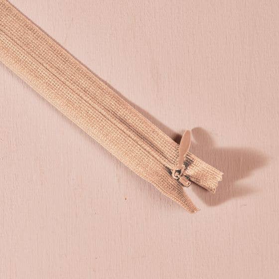 Atelier Brunette invisible zipper in sand beige, 40 cm (16 inch), a dressmaking notion for dresses and skirts shown on a blush background