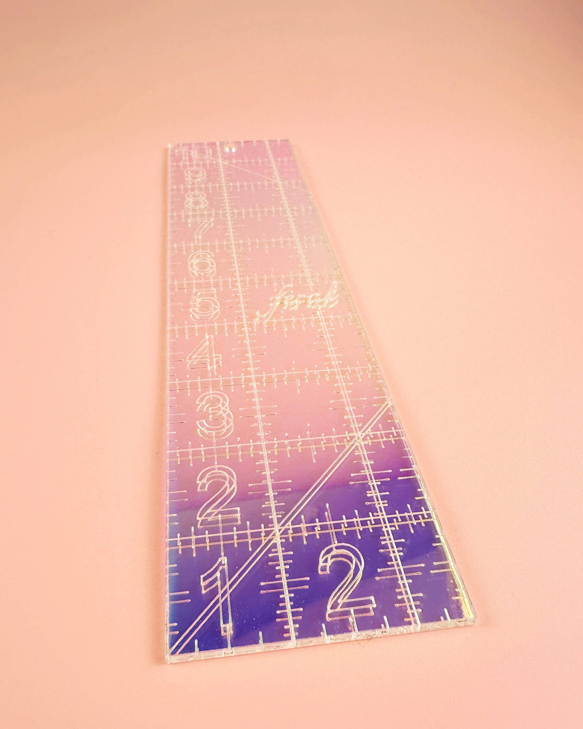 Feral Notions 2.5 x 10 inch quilting ruler in iridescent acrylic angled to show the color shift