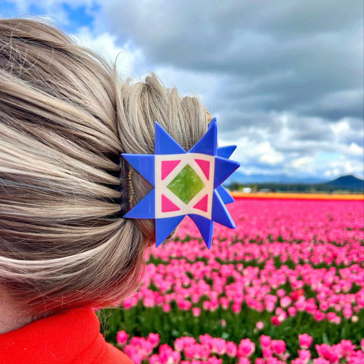 The Peach Fuzz quilt hair claw in hair against a cloudy sky