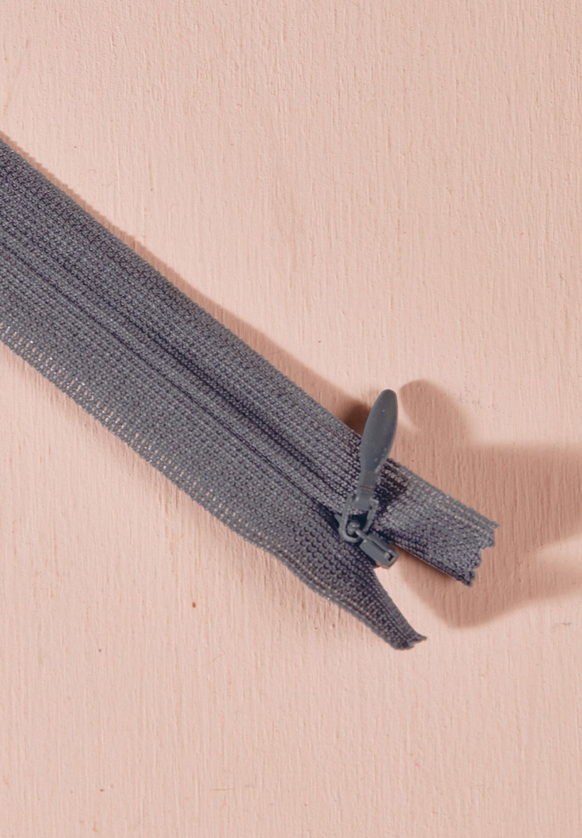 Atelier Brunette invisible zipper in slate grey, 40 cm (16 inch), a dressmaking notion for dresses and skirts shown on a blush background