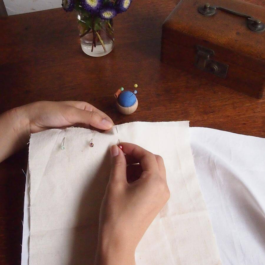 Cohana Tombo-dama glass sewing pins, pinning fabric by hand at a sewing table