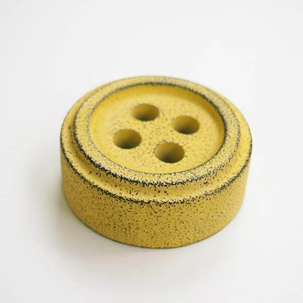 Cohana Nambu iron paperweight and pattern weight, shaped like a yellow button