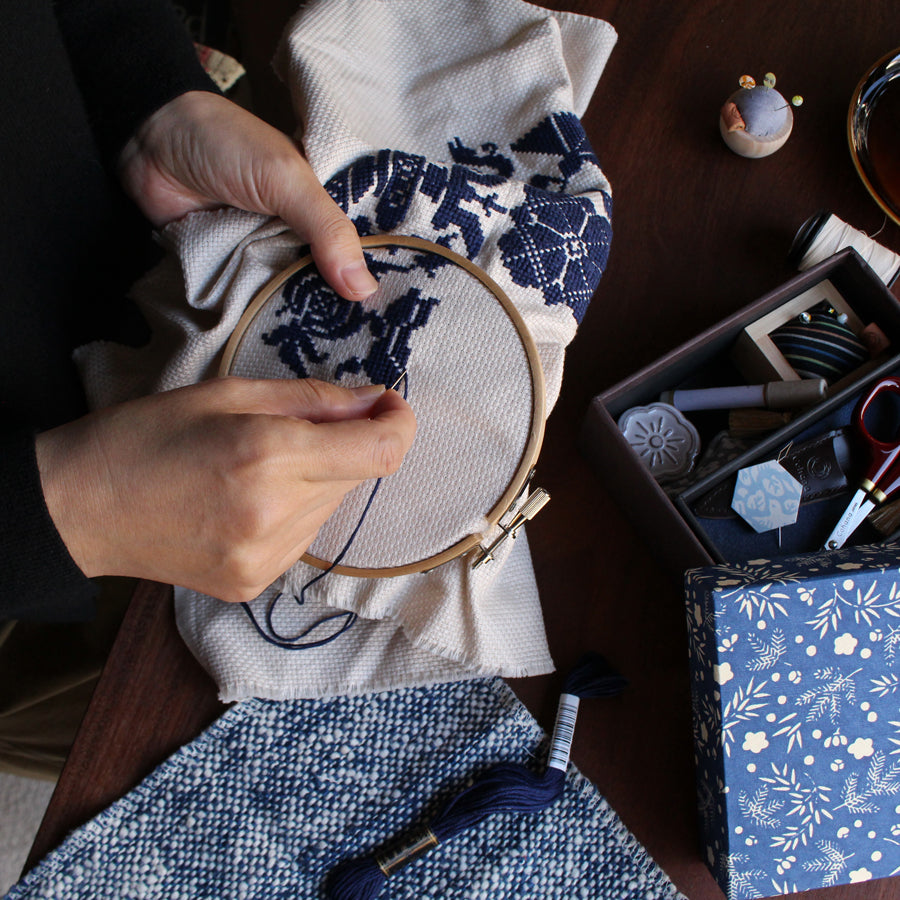 Cohana assorted needles in a Haibara chiyogami paper pack, being stitched with on denim