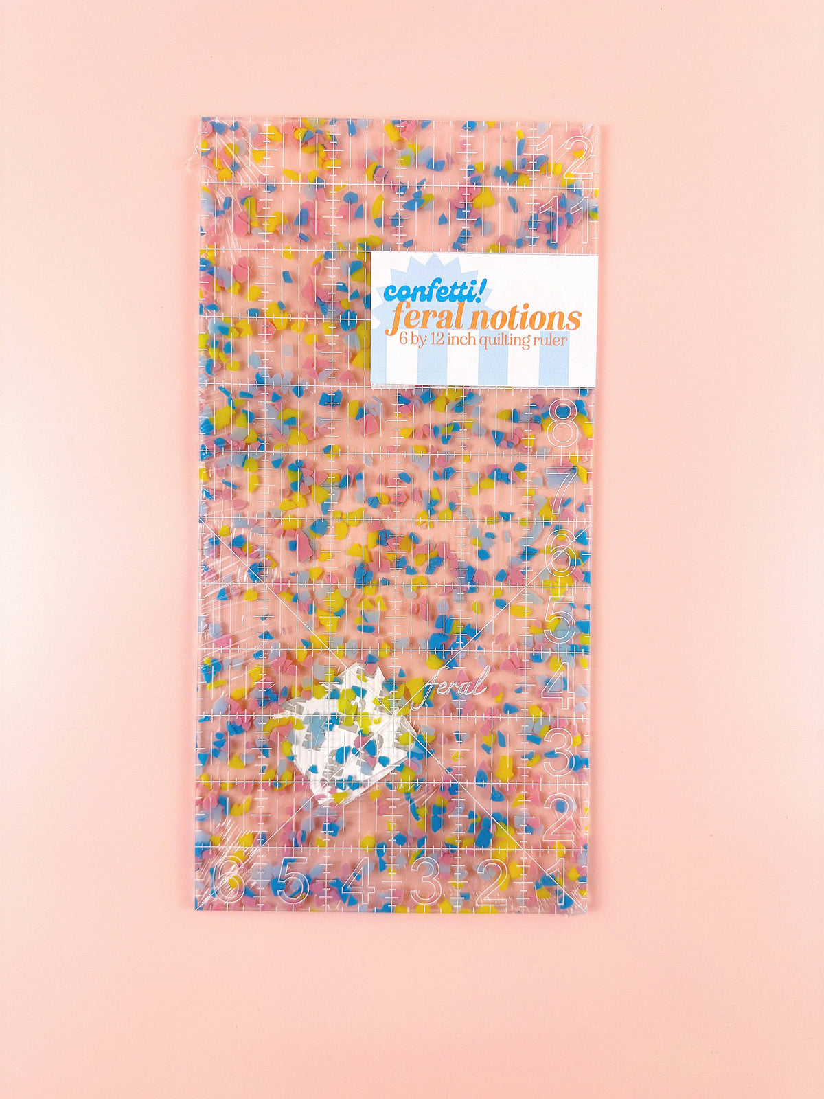 Feral Notions 6 x 12 inch quilting ruler in rainbow confetti acrylic with its paper label