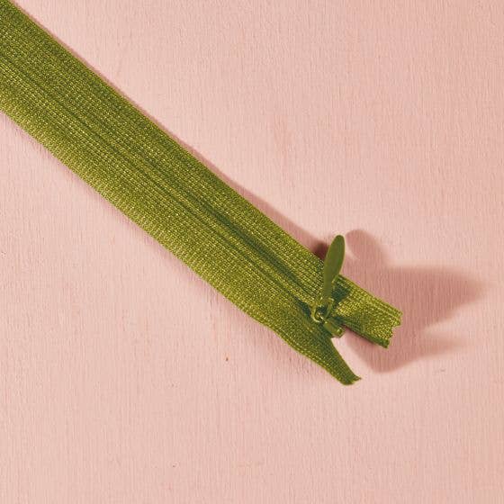 Atelier Brunette invisible zipper in matcha green, 60 cm (24 inch), a dressmaking notion for dresses and skirts shown on a blush background