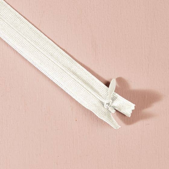 Atelier Brunette invisible zipper in off-white, 40 cm (16 inch), a dressmaking notion for dresses and skirts shown on a blush background