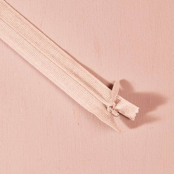 Atelier Brunette invisible zipper in blush pink, 40 cm (16 inch), a dressmaking notion for dresses and skirts shown on a blush background