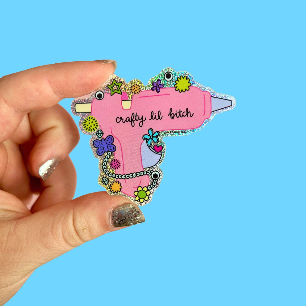 The Peach Fuzz Crafty Lil Bitch glue gun glitter sticker on blue
