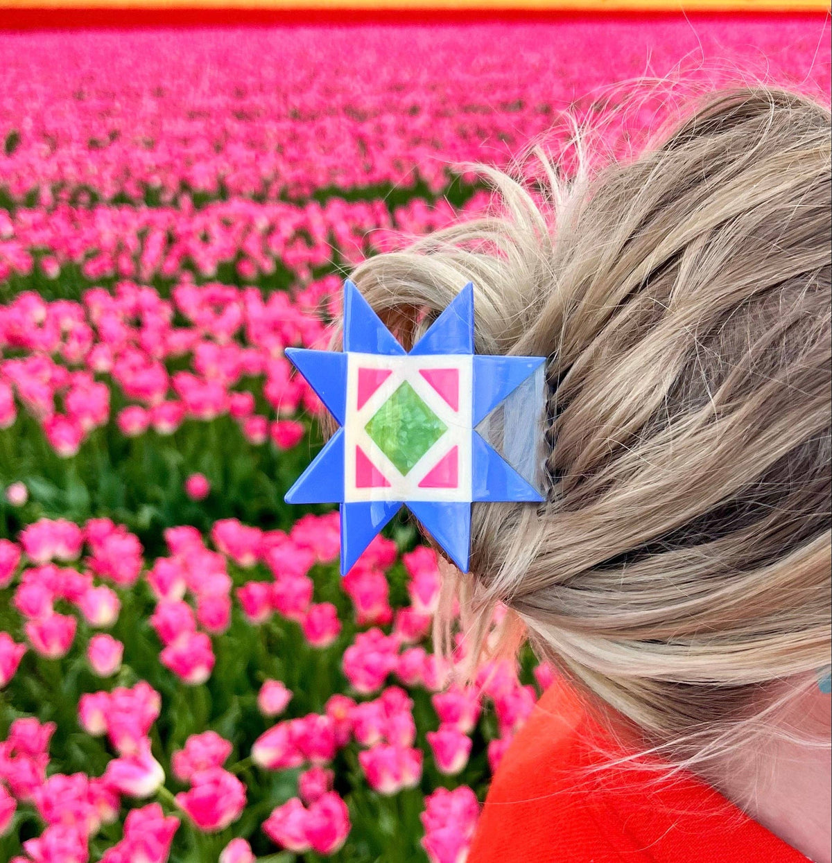 The Peach Fuzz quilt block hair claw in hair, back view in a tulip field