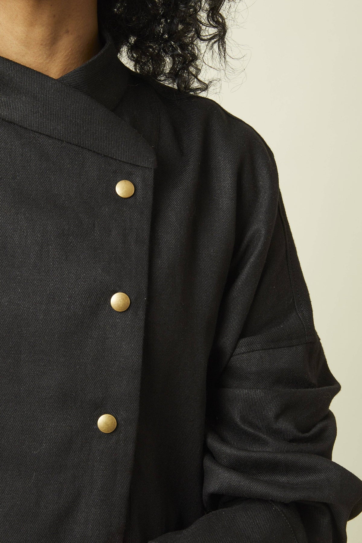 Close-up of the collar and buttons on a black jacket sewn from the Atelier Brunette Troubling Jacket printed sewing pattern