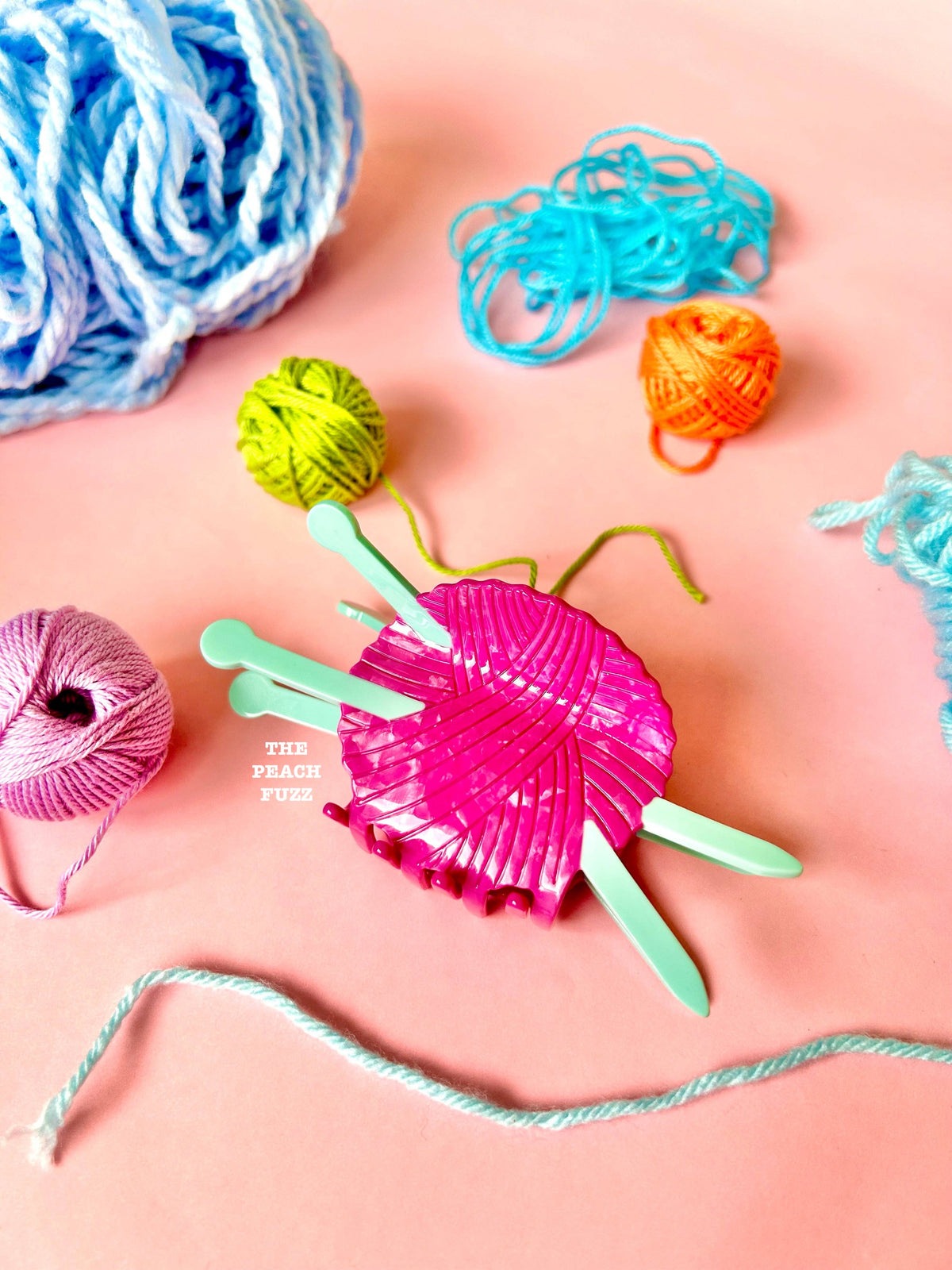 The Peach Fuzz knitting needle hair claw with yarn balls, a gift for knitters