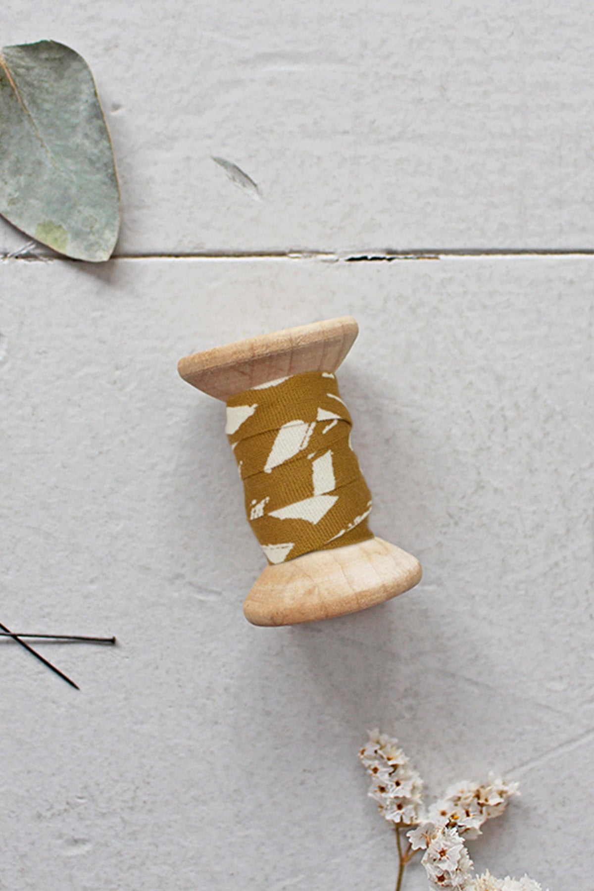 Atelier Brunette ochre bias tape spool with leaves, side view