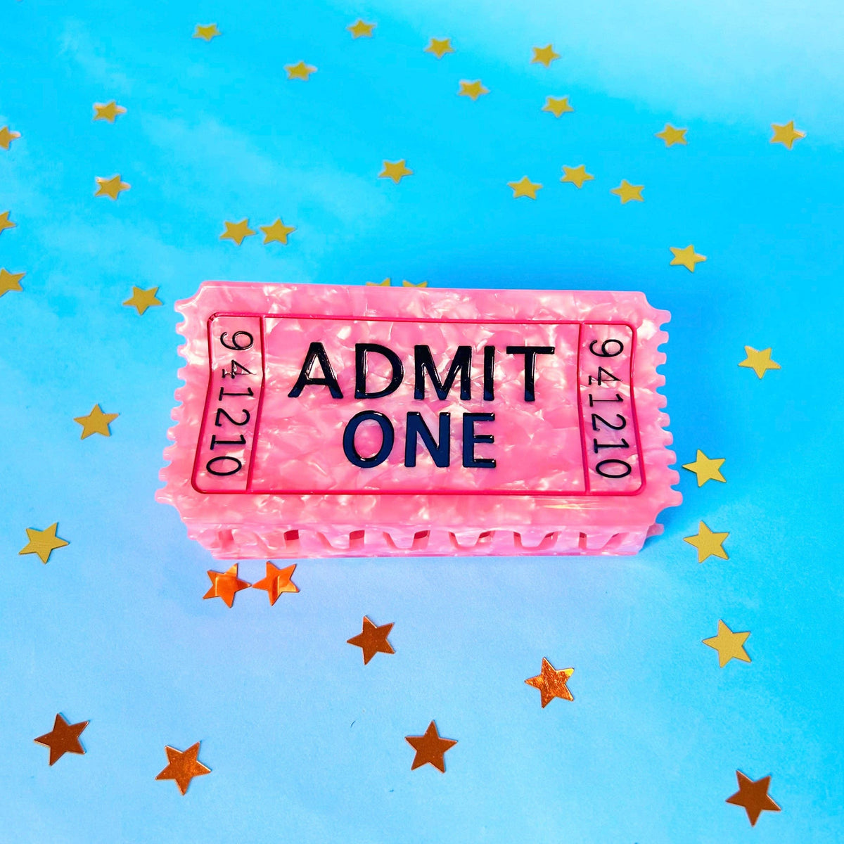 The Peach Fuzz pink Admit One ticket hair claw on blue with confetti