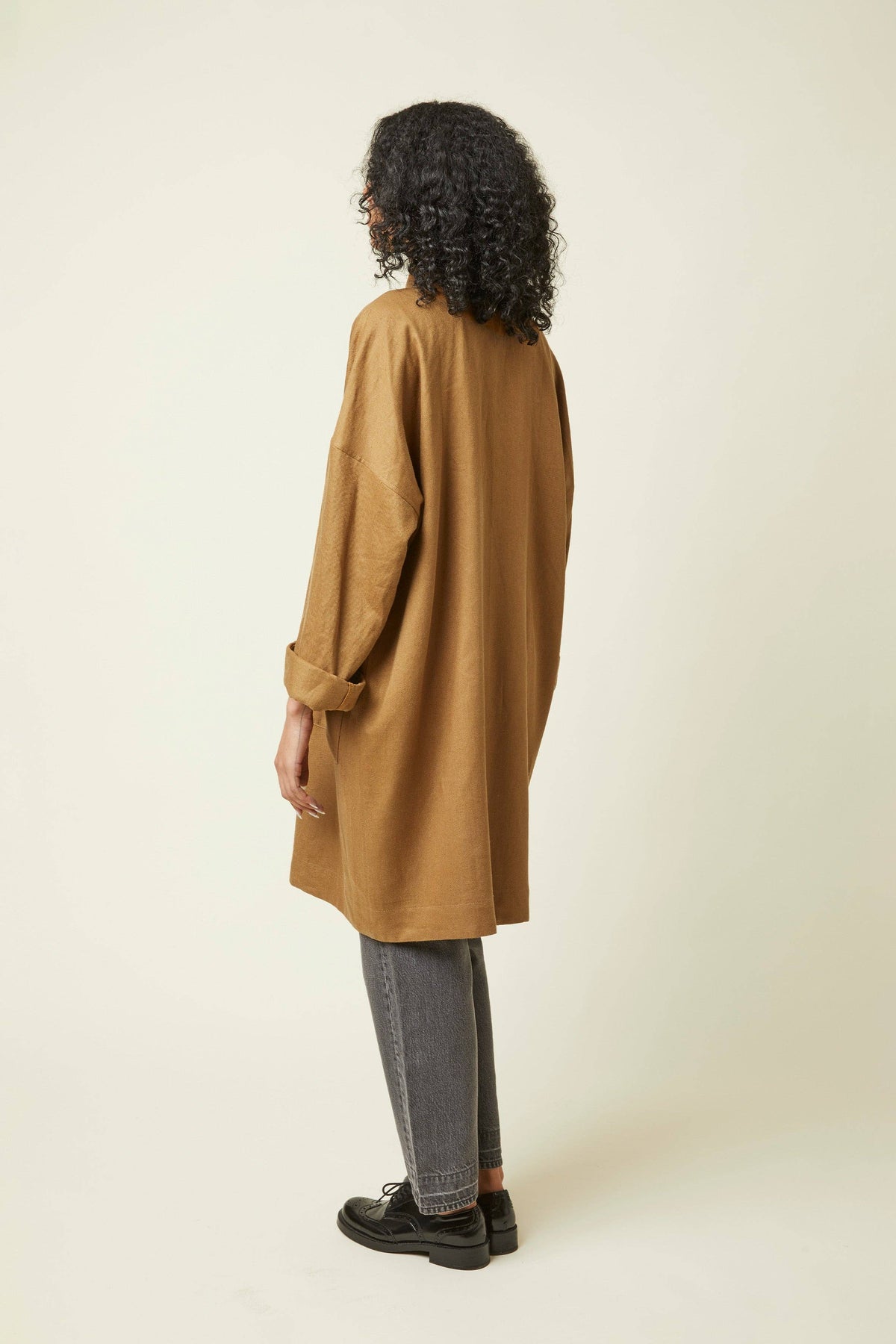 Side view of a camel jacket made with the Atelier Brunette Troubling Jacket printed sewing pattern