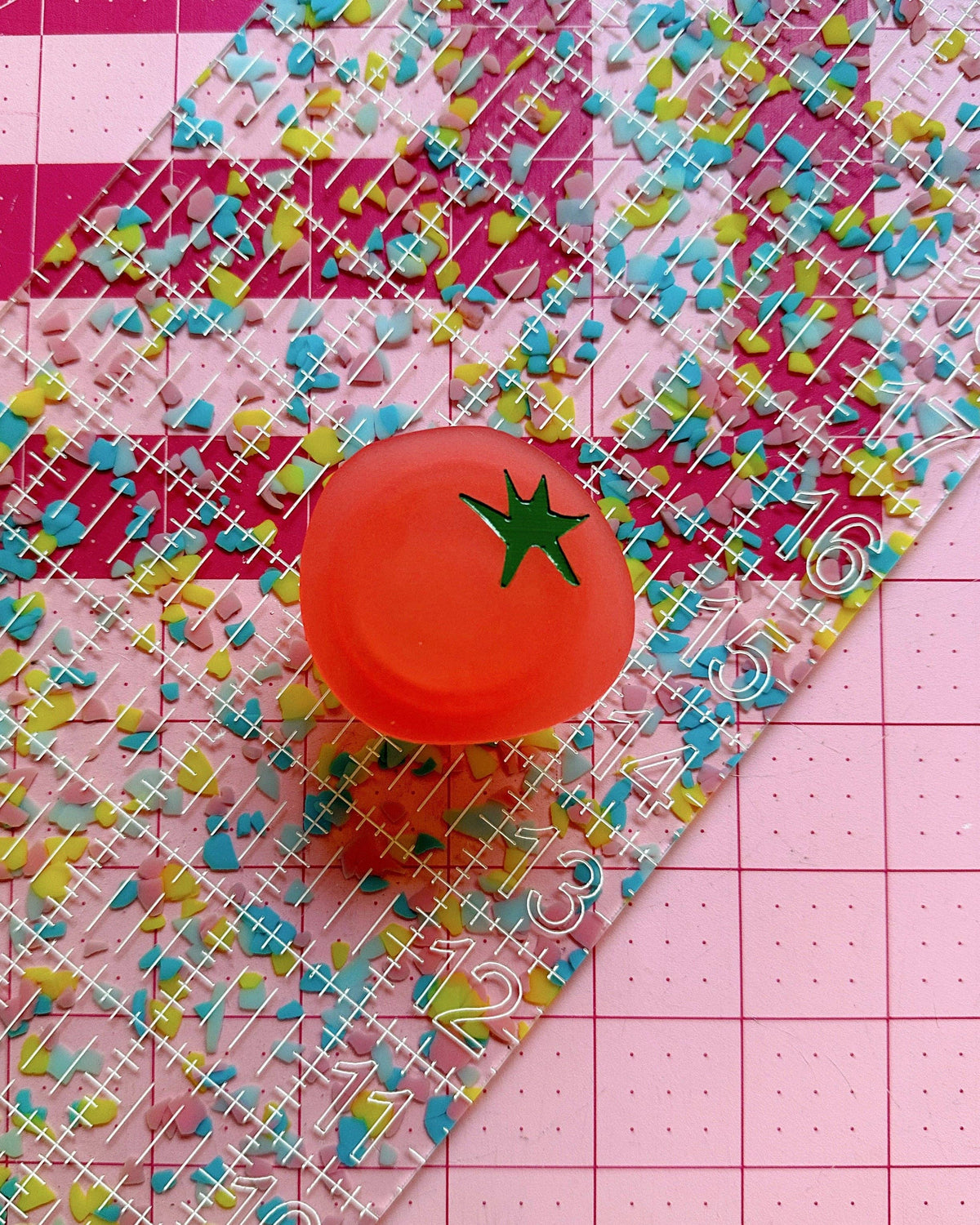 Feral Notions tomato pop-up ruler handle stuck to a confetti acrylic quilting ruler