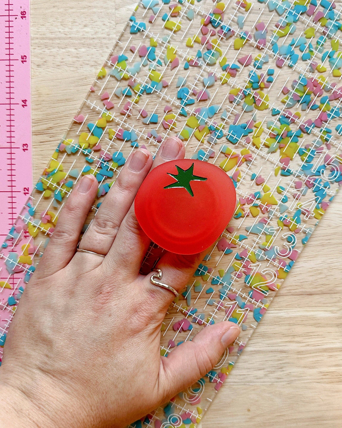 Feral Notions tomato ruler handle on a confetti quilting ruler shown from above