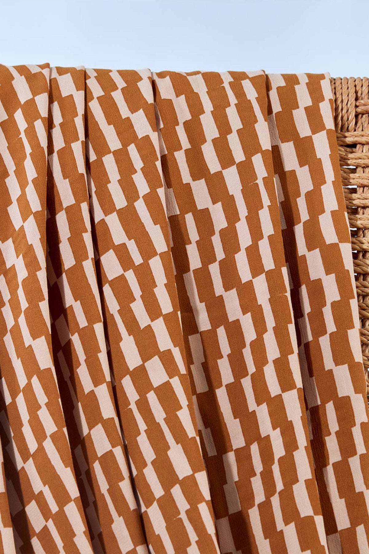 Atelier Brunette Domino Ochre viscose fabric with an ochre and cream wave print, draped