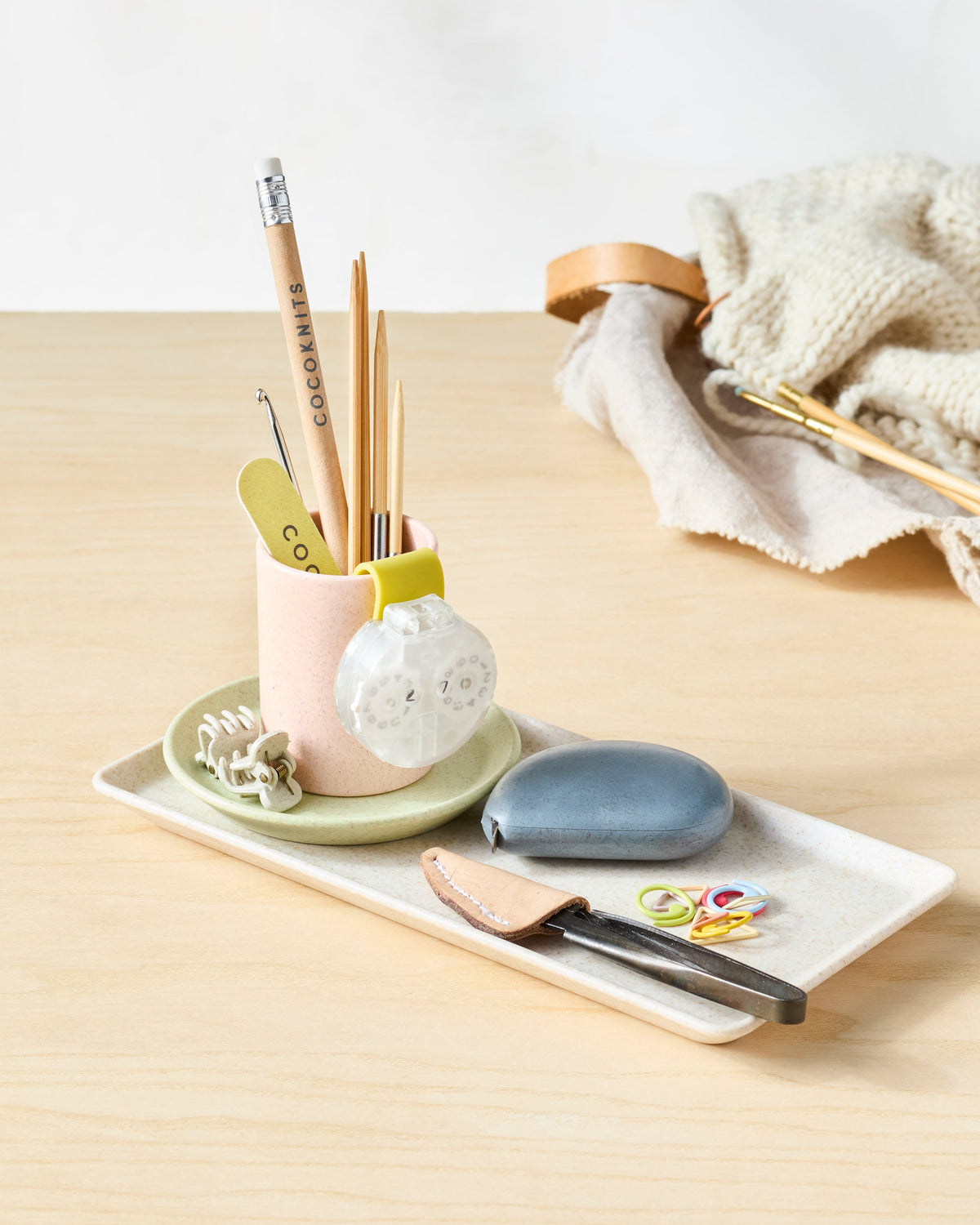 CocoKnits notions dish on a craft table with yarn and tools