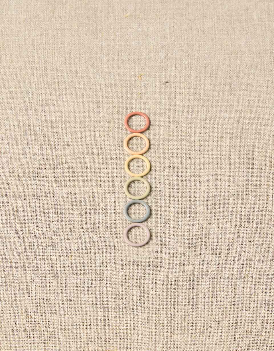 CocoKnits earth tone ring stitch markers in a vertical row for knitting