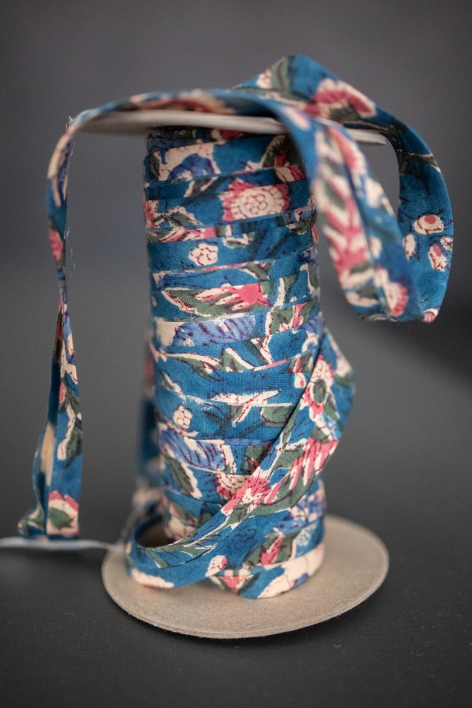 Merchant & Mills Storybook bias binding unwound from its spool, cotton bias tape