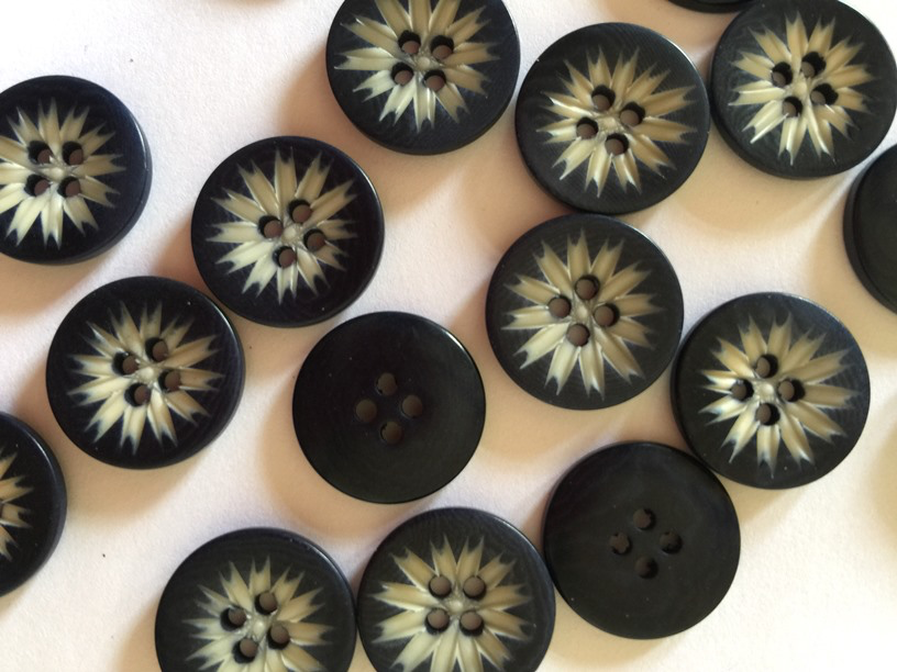 Black buttons with starburst patterns on a white background