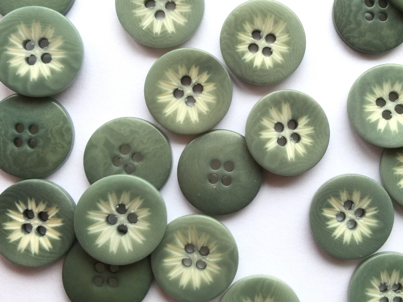 Green buttons with floral patterns on a white background