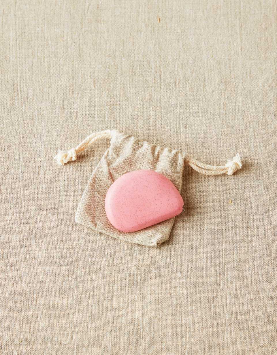 CocoKnits tape measure in Wild Rose, a pink stone shaped retractable sewing and knitting tape, with its cotton drawstring pouch