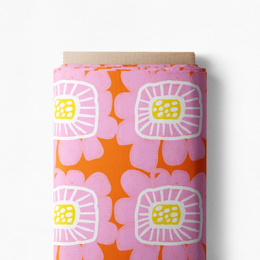 Riku Flower in Apricot print on a bolt, large pink flowers with yellow centers on orange