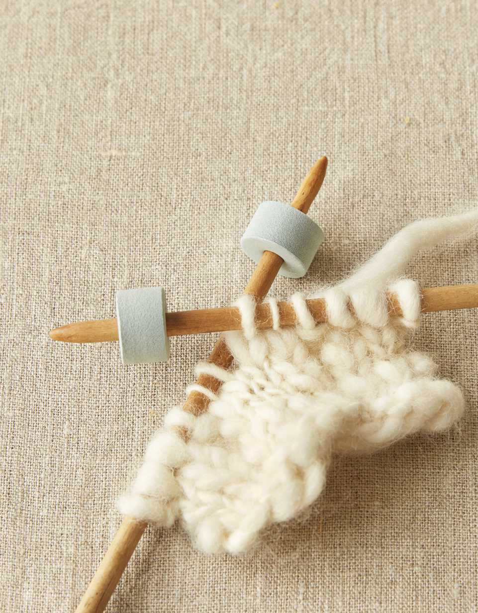 CocoKnits stitch stoppers on knitting needle tips with cream knitting