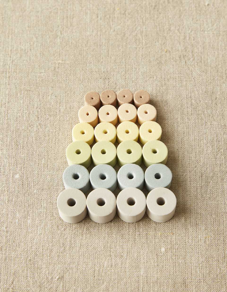 CocoKnits stitch stoppers in earth tones, needle point protectors in rows