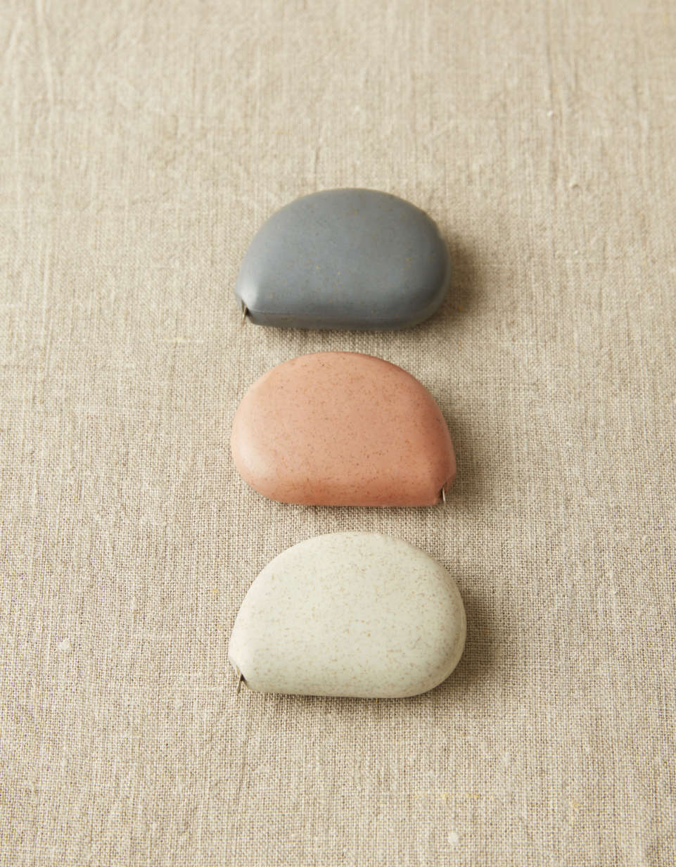 CocoKnits tape measure in Clay, a terracotta stone shaped retractable sewing and knitting tape, stacked in three, close-up