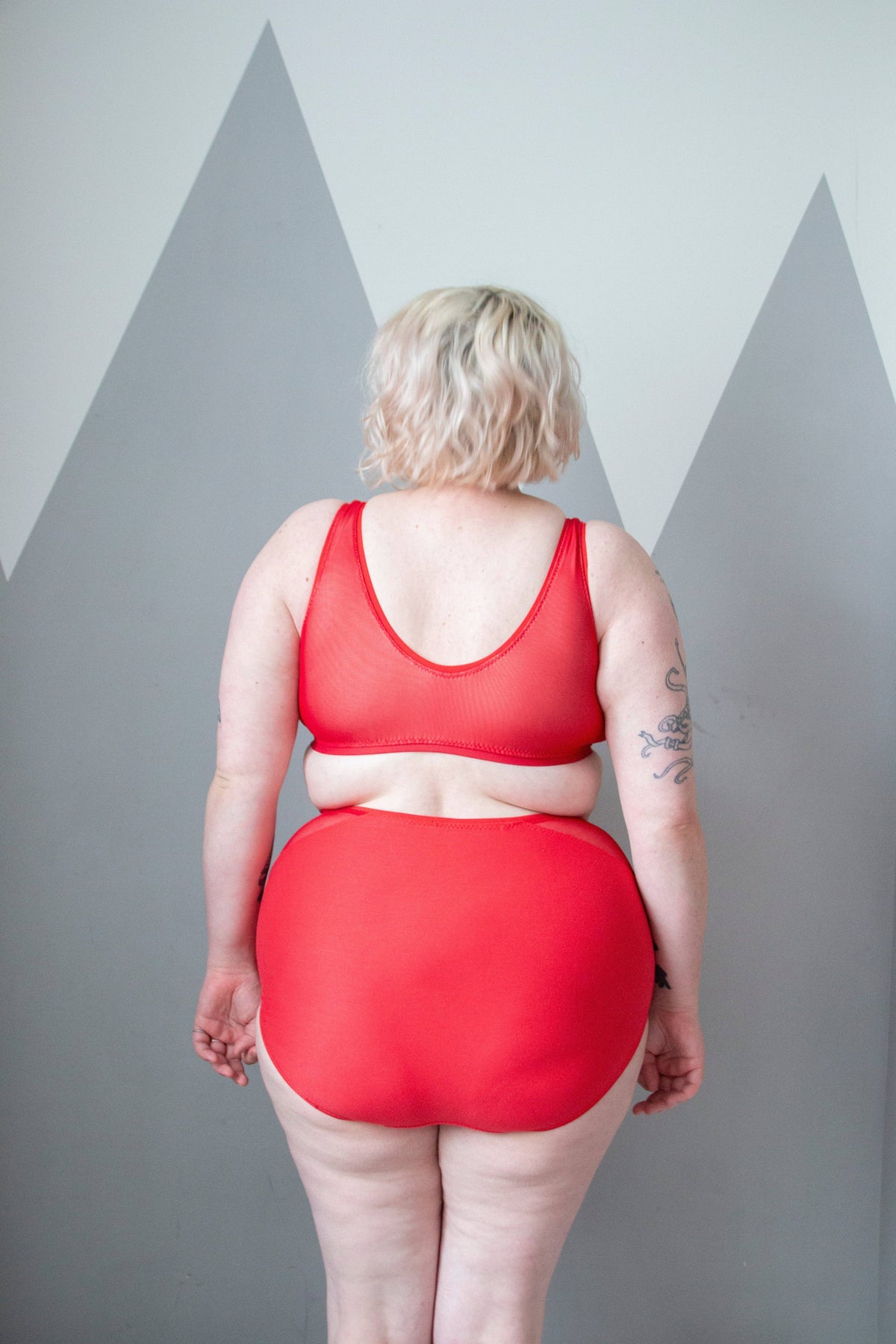 Model in red high-waist knickers from the Sophie Hines Median Knickers sewing pattern, three quarter view