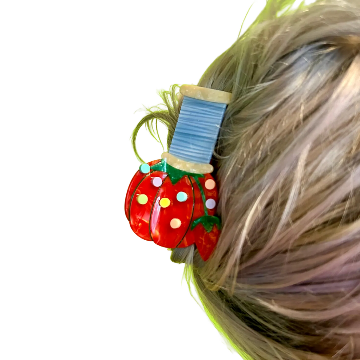 The Peach Fuzz pin cushion hair claw shaped like a tomato pincushion in brown hair