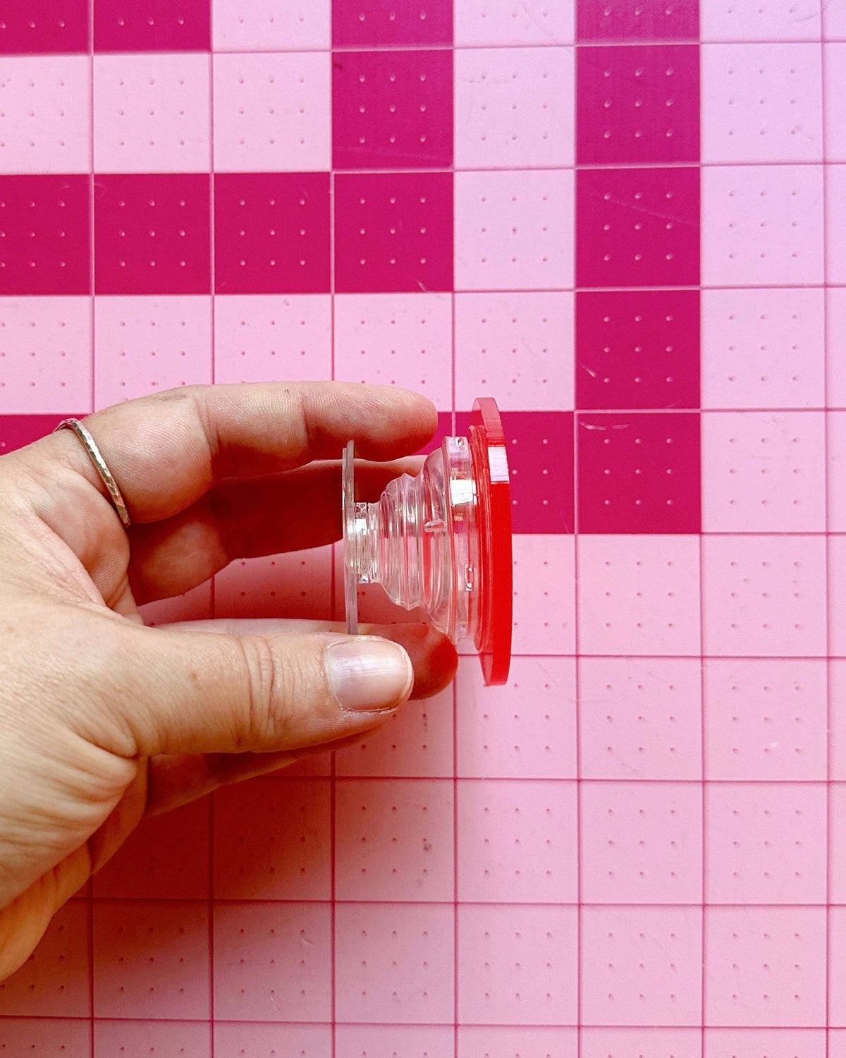 Hand lifting a quilting ruler with the Feral Notions tomato pop-up handle
