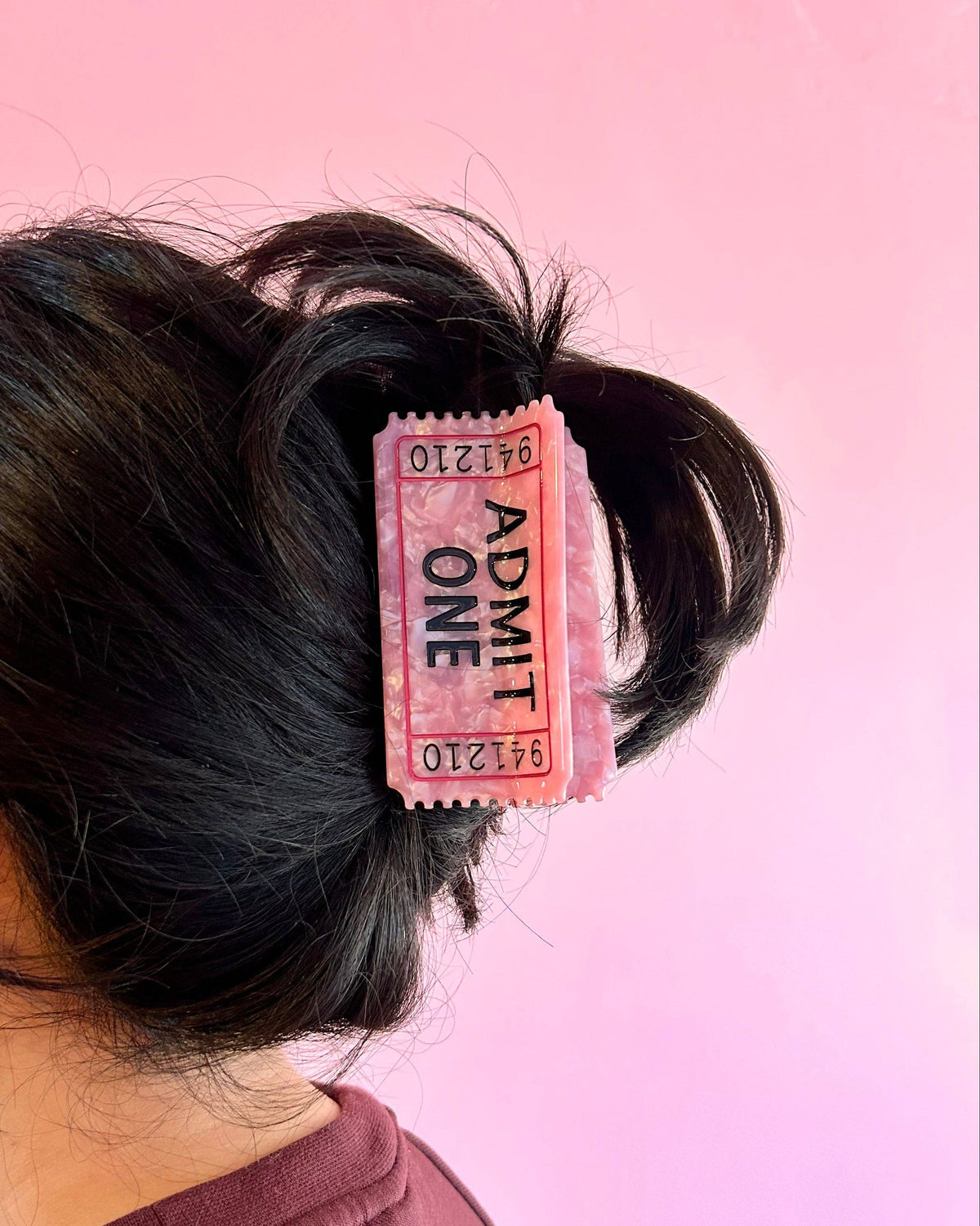 The Peach Fuzz ticket hair claw clipped in dark hair