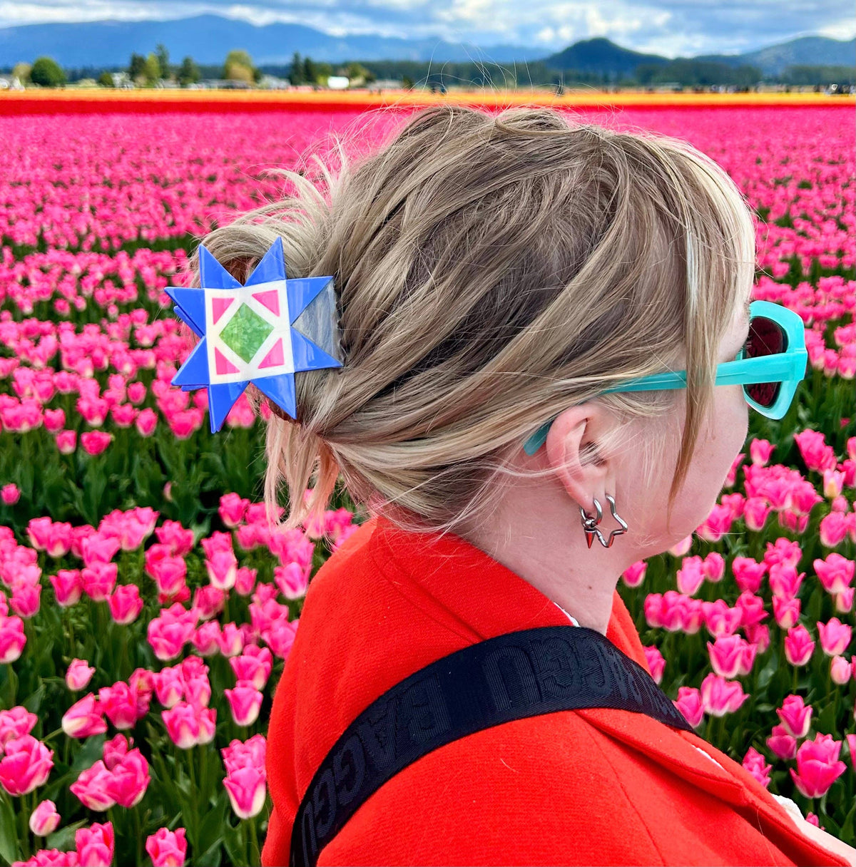 The Peach Fuzz quilt block hair claw worn in blonde hair in a tulip field