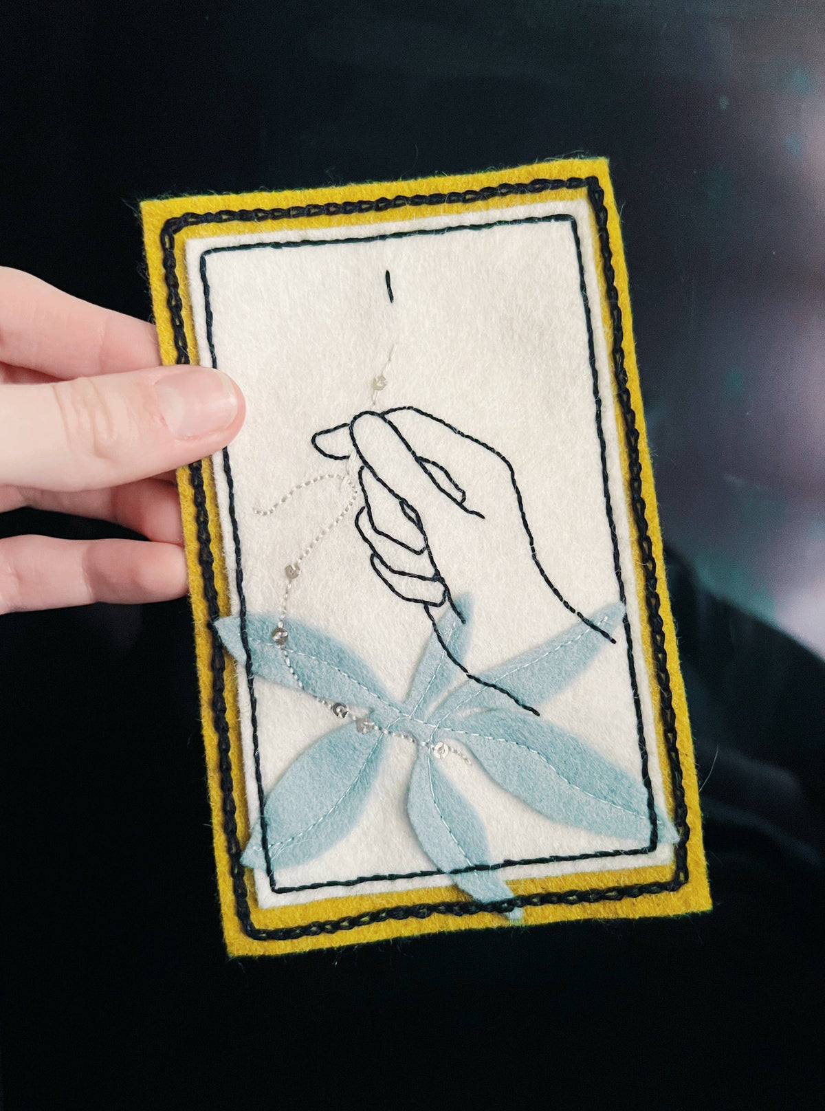 Sophie Hines The Magician tarot patch embroidery pattern card with a hand and gold border on dark fabric