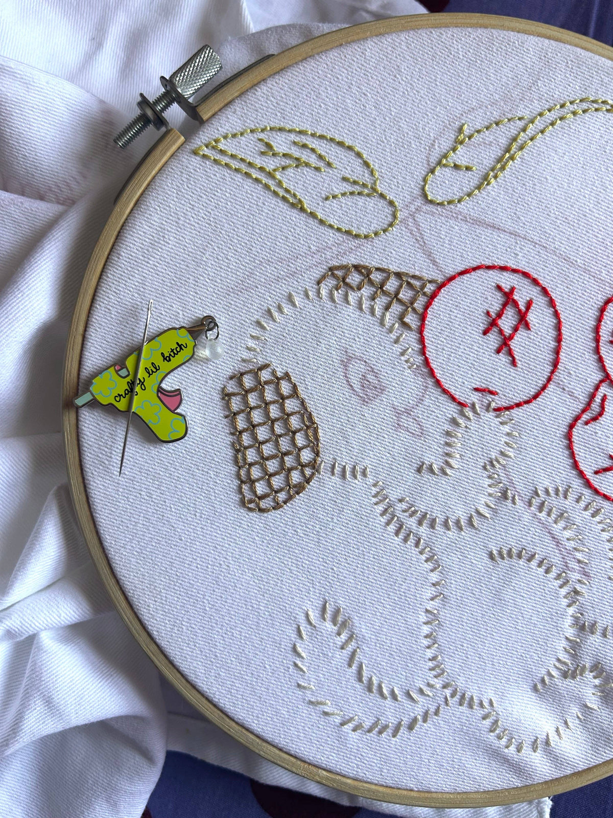 The Peach Fuzz Crafty Lil Bitch needle minder on an embroidery hoop