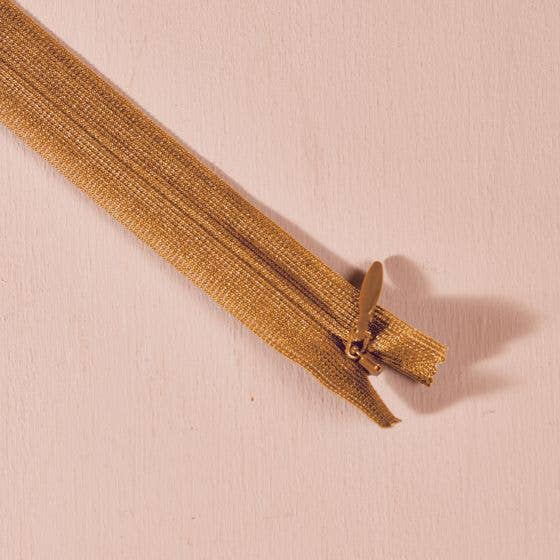 Atelier Brunette invisible zipper in ochre, 40 cm (16 inch), a dressmaking notion for dresses and skirts shown on a blush background