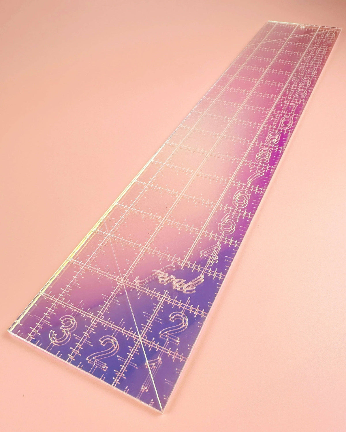 Feral Notions fat quarter quilting ruler in iridescent acrylic angled to catch the rainbow shimmer