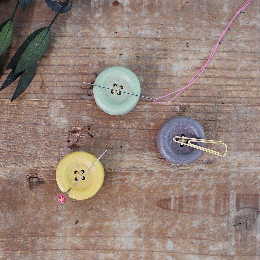 Cohana Shigaraki ware button magnet, on a wood table with pins