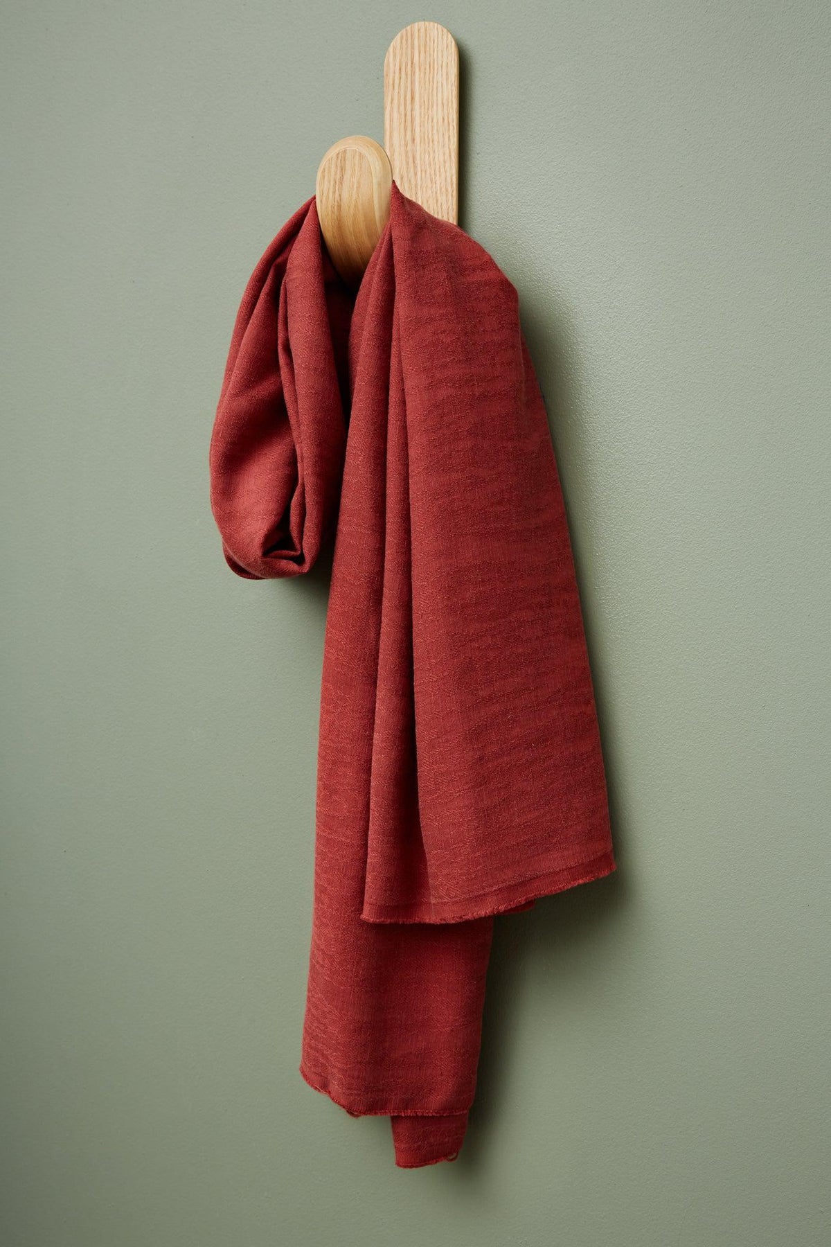 meetMILK Hoya jacquard linen blend in Cider, red textured dressmaking fabric hanging on a hook