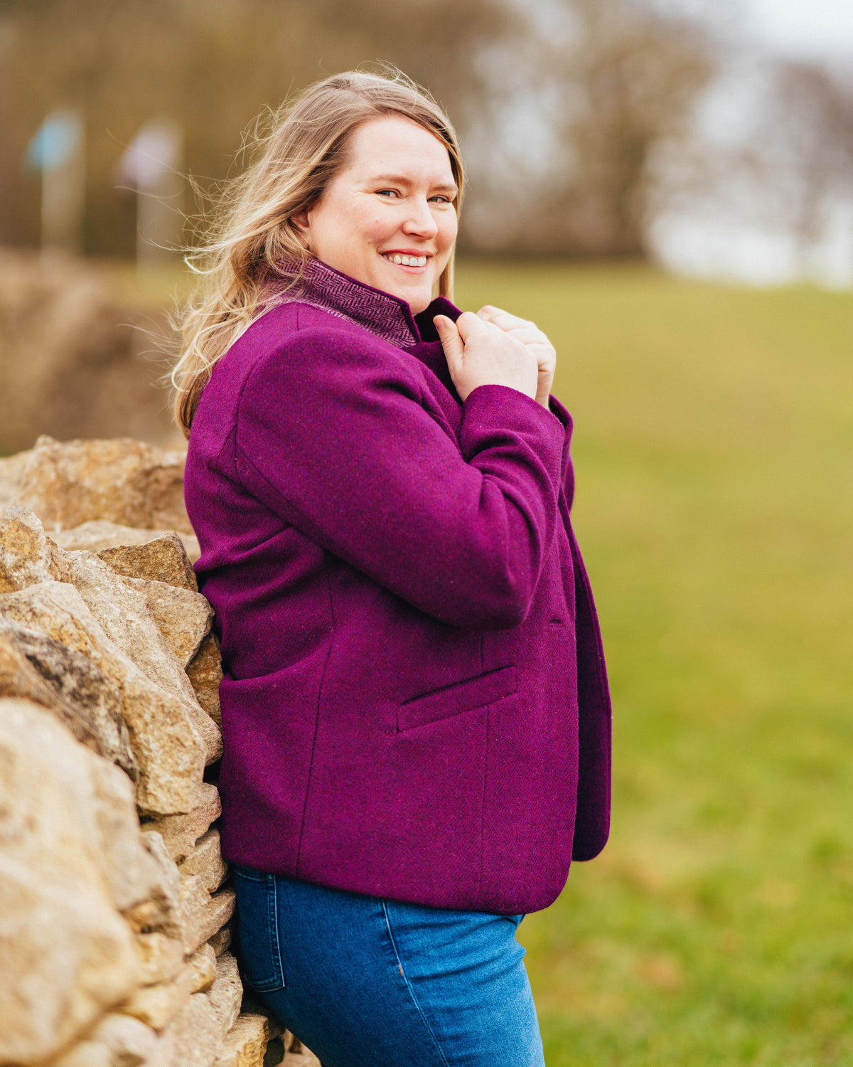 Cashmerette Auburn Blazer PDF sewing pattern, woman in a purple coat standing next to a stone wall with a blurred natural background