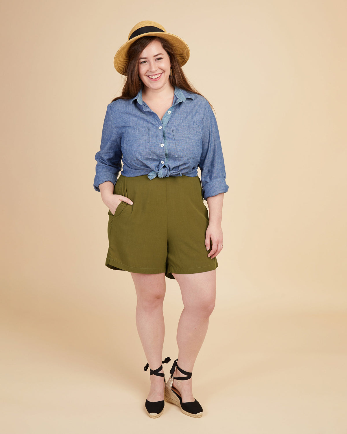 Cashmerette Calder Pants and Shorts PDF sewing pattern, woman wearing a blue shirt and green shorts with a beige hat