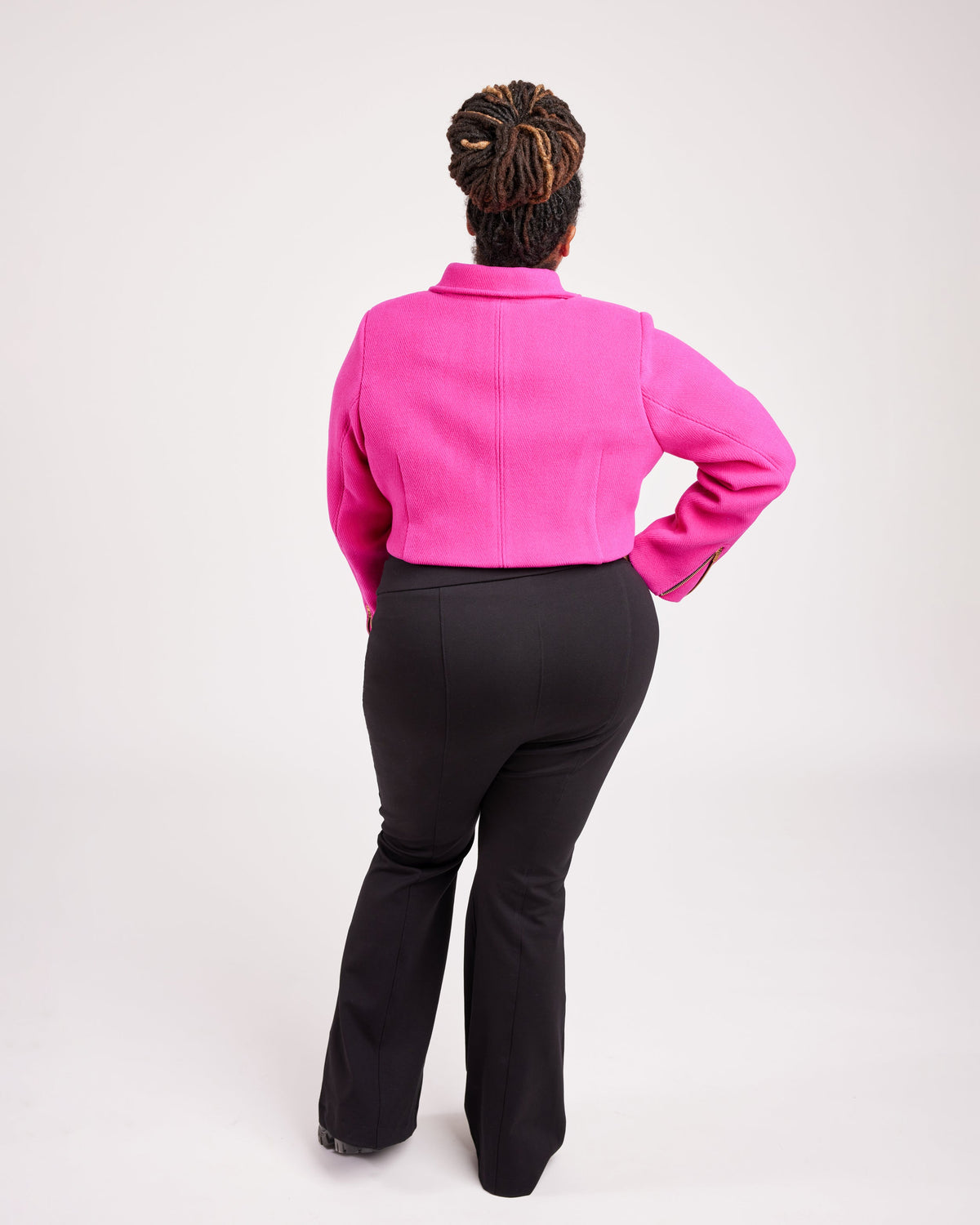Cashmerette Canton Moto Jacket PDF sewing pattern, person wearing a bright pink jacket and black pants, side view