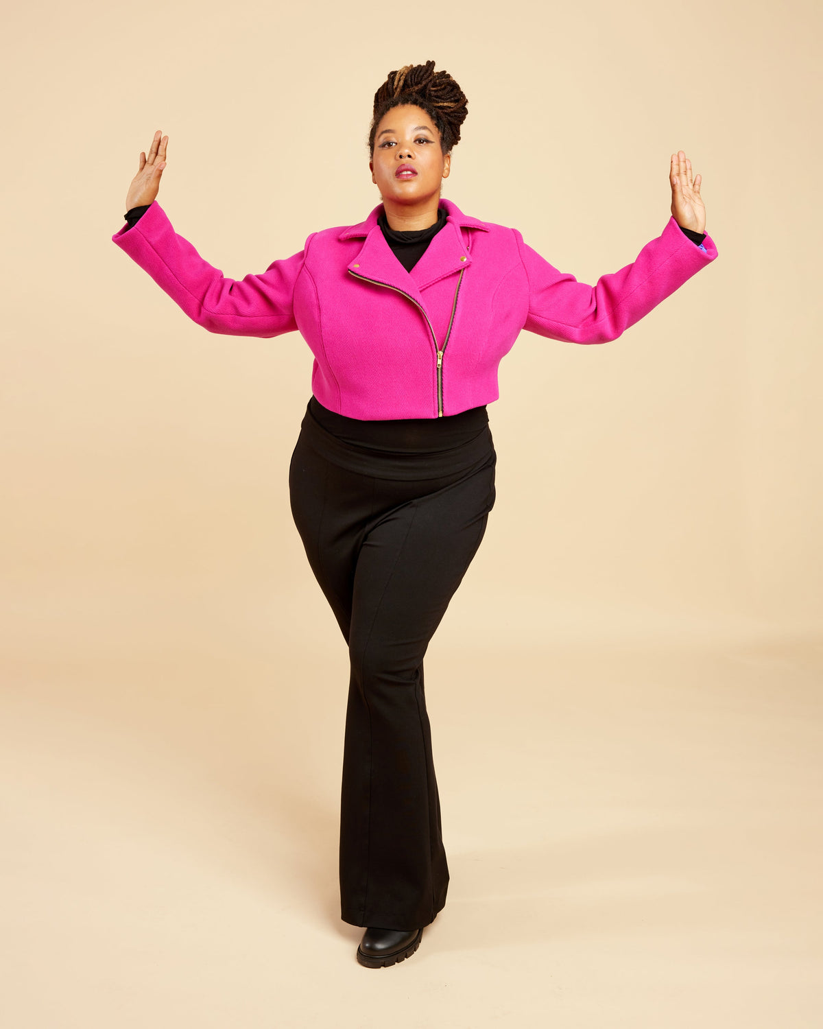 Cashmerette Canton Moto Jacket PDF sewing pattern, person wearing a bright pink jacket and black pants, arms outstretched