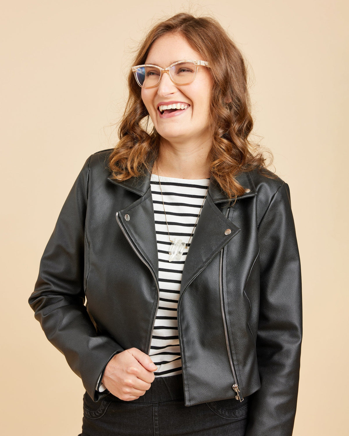 Cashmerette Canton Moto Jacket PDF sewing pattern, woman wearing a black leather jacket over a striped shirt, smiling close-up