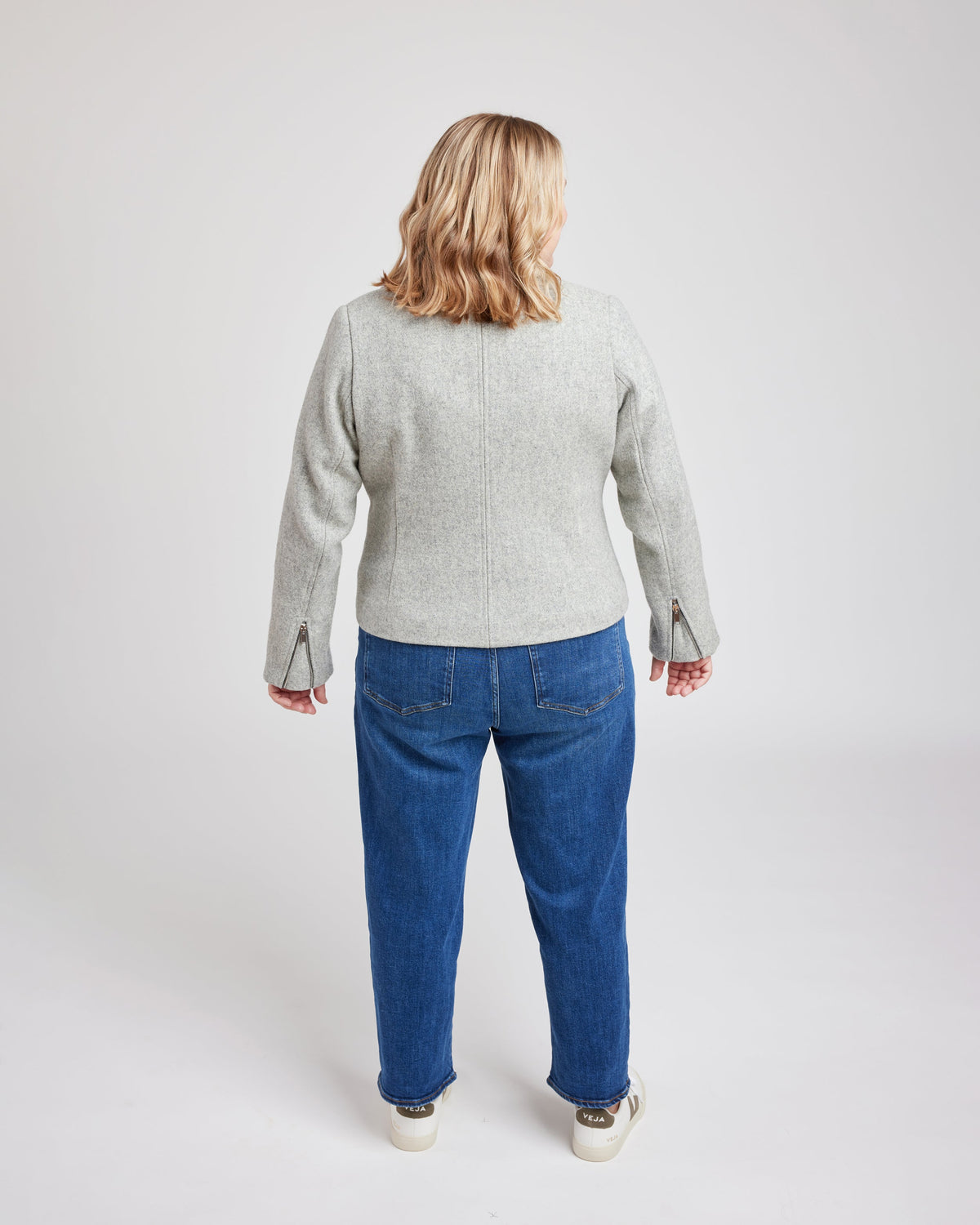 Cashmerette Canton Moto Jacket PDF sewing pattern, person wearing a gray jacket and blue jeans, three quarter view